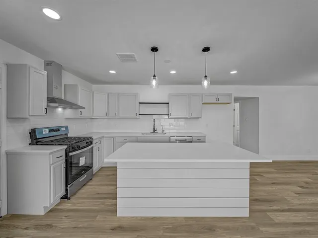 a view of kitchen with wooden floor and stainless steel appliances