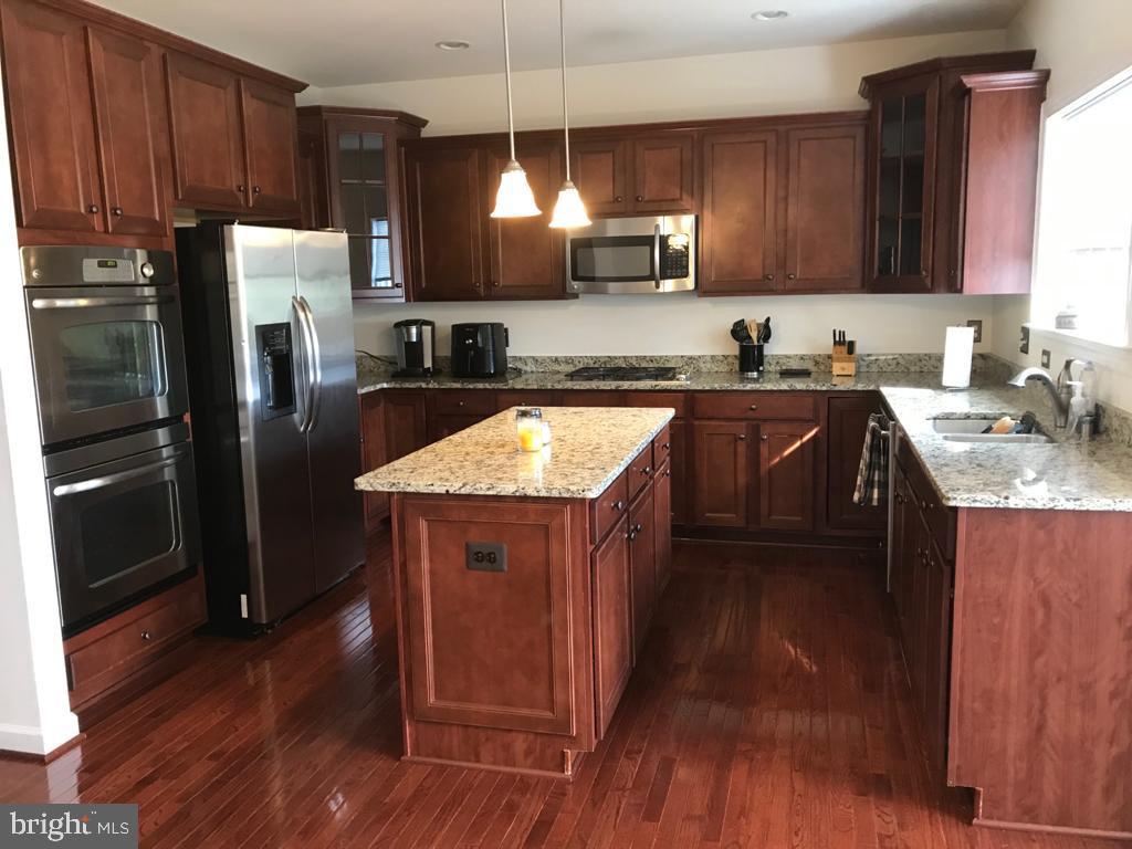 25196 Prairie Fire Square Aldie, VA 20105 - Photo 2 of 9 Modern kitchen with rich wood tones.