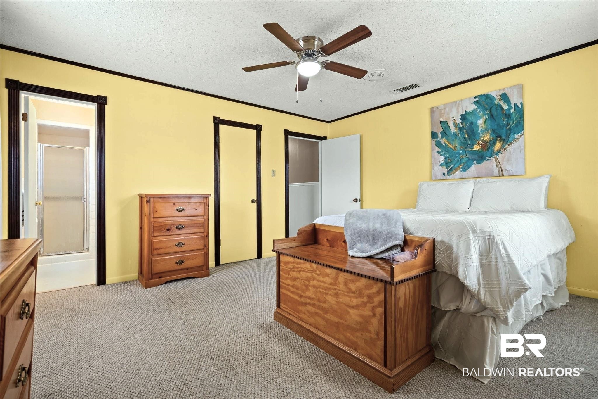 8090 Murray Hill Road Irvington, AL 36544 - Photo 18 of 40 Bedroom featuring a ceiling fan, light carpet, a textured ceiling, and crown molding