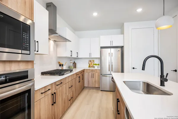 a kitchen with white cabinets and stainless steel appliances