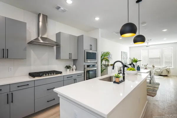 a kitchen that has a lot of cabinets and appliances