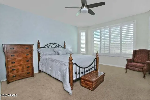 a bedroom with a bed a dresser and a window