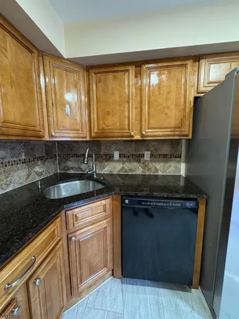 a kitchen with granite countertop cabinets sink and large window