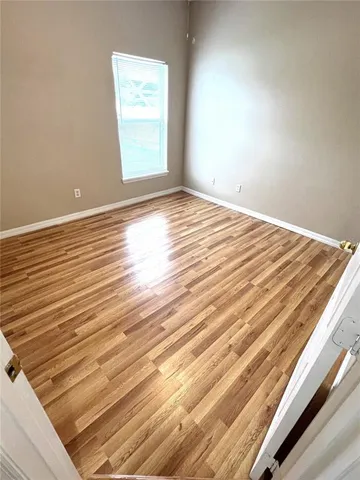 a view of a room with wooden floor and window