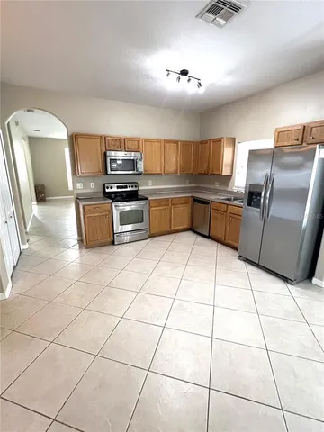 a kitchen with granite countertop a stove a sink and a microwave