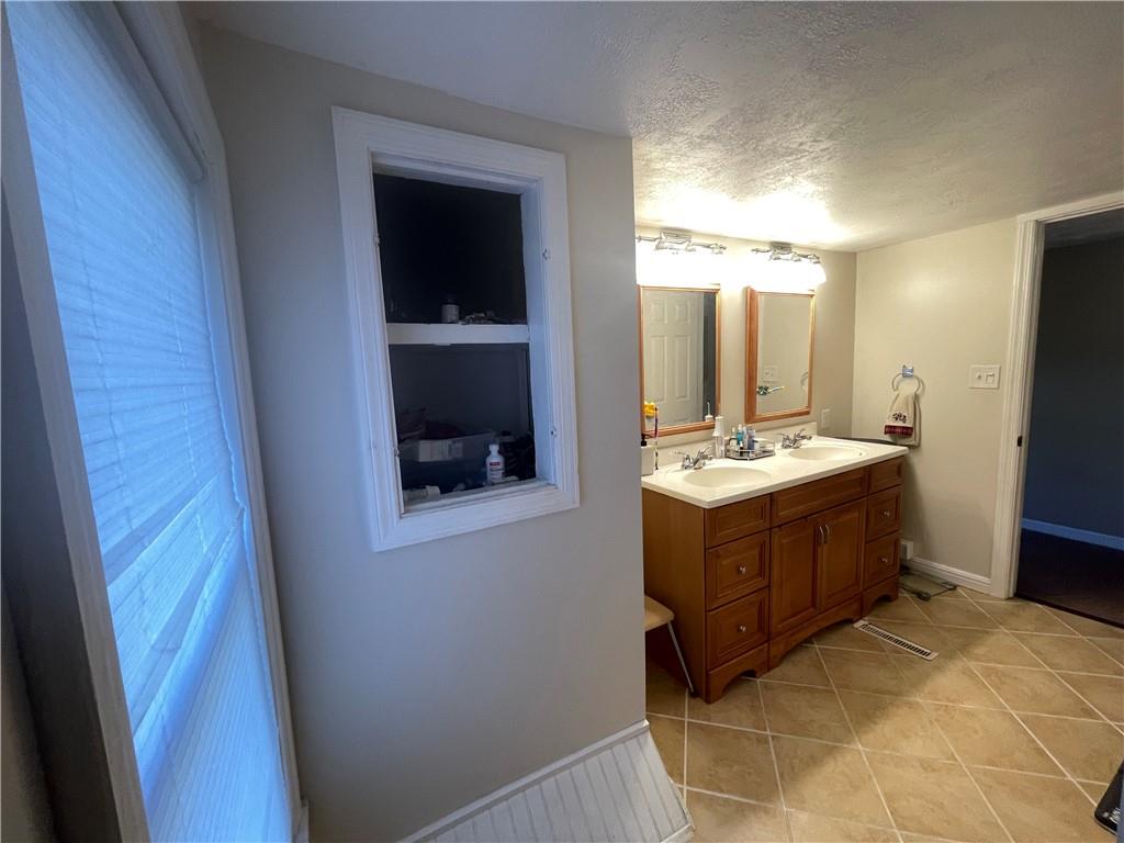 69 Hewitt Avenue Washington, PA 15301 - Photo 16 of 27 a bathroom with a double vanity sink and mirror