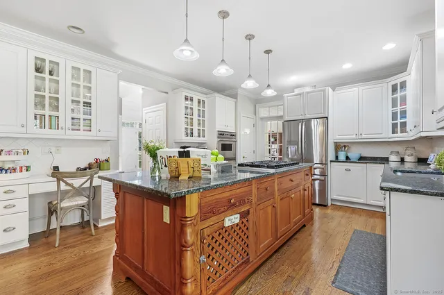 a kitchen with stainless steel appliances kitchen island granite countertop a sink and cabinets