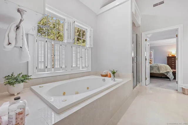 a bathroom with a tub sink and mirror