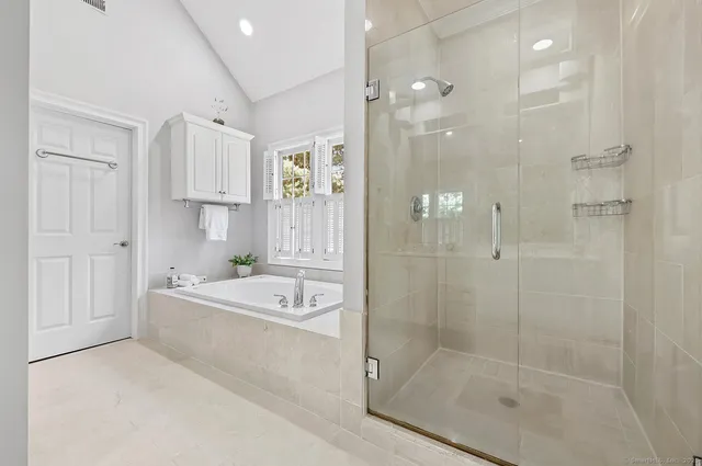 a bathroom with a bathtub shower sink vanity and mirror