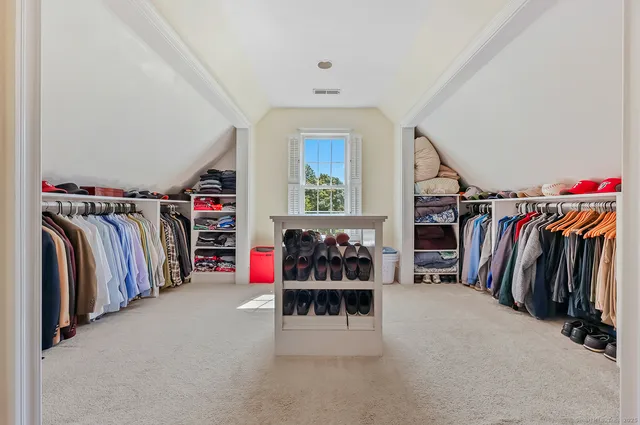 a view of walk in closet with clothes and shoes