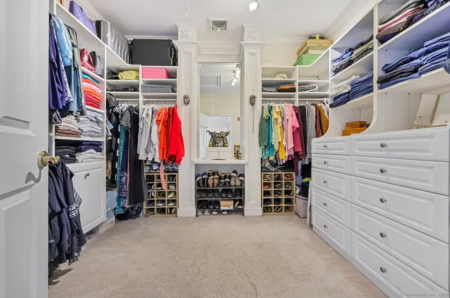 a view of walk in closet with clothes