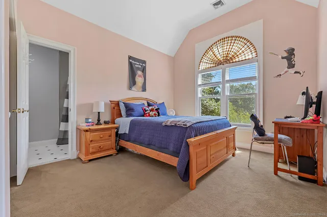 a bedroom with a bed and a table chair