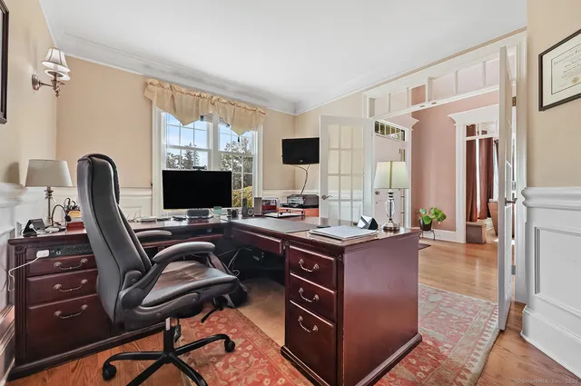 a view of a workspace with furniture and a window