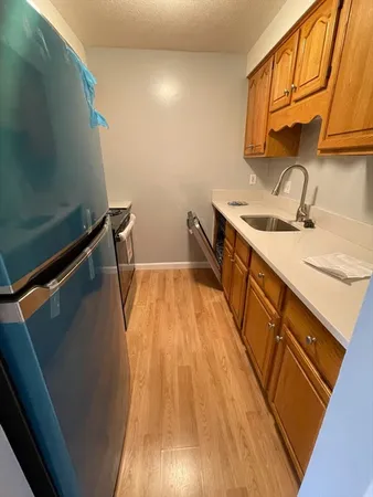 a view of a kitchen with a sink and wooden floor