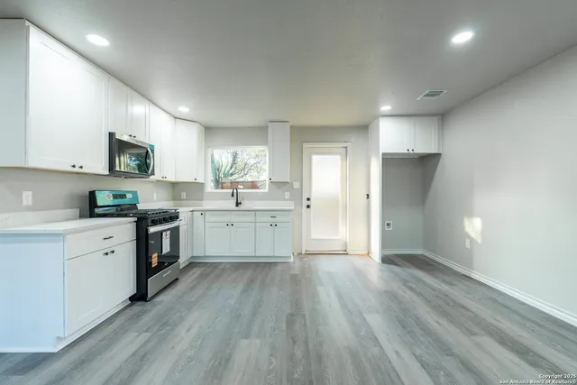 a kitchen with granite countertop a stove and a sink