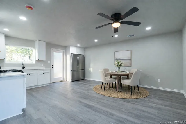a view of a kitchen with a sink a ceiling fan and wooden floor