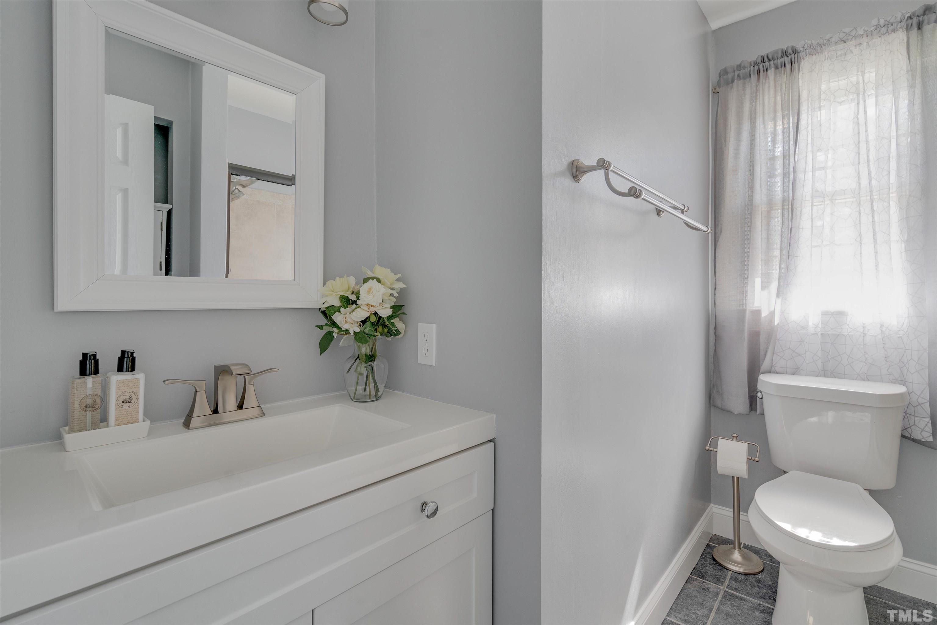 4124 Green Road Raleigh, NC 27604 - Photo 5 of 18 a bathroom with a toilet sink and mirror