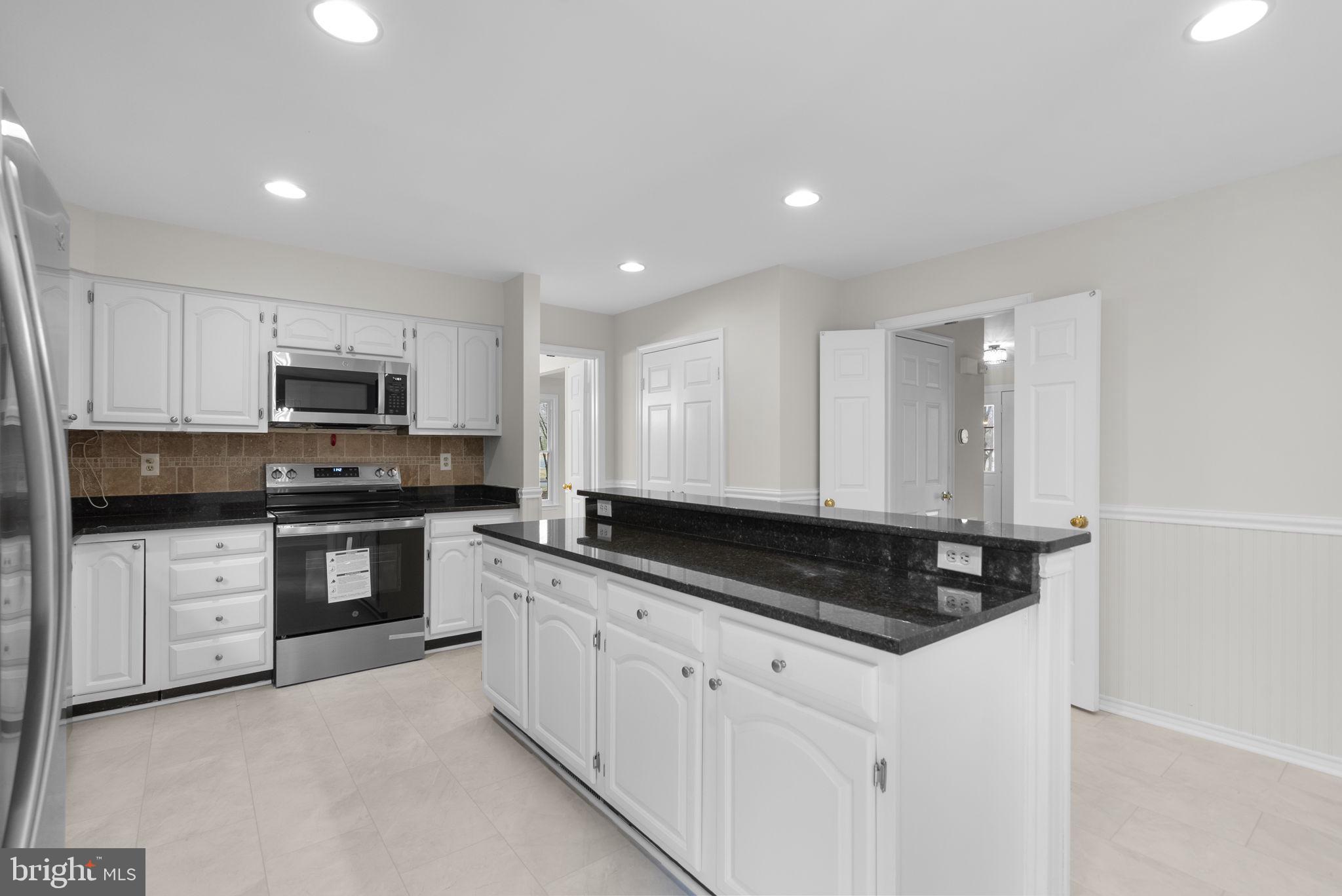14724 Harvest Lane Silver Spring, MD 20905 - Photo 16 of 53 a kitchen with granite countertop white cabinets and stainless steel appliances
