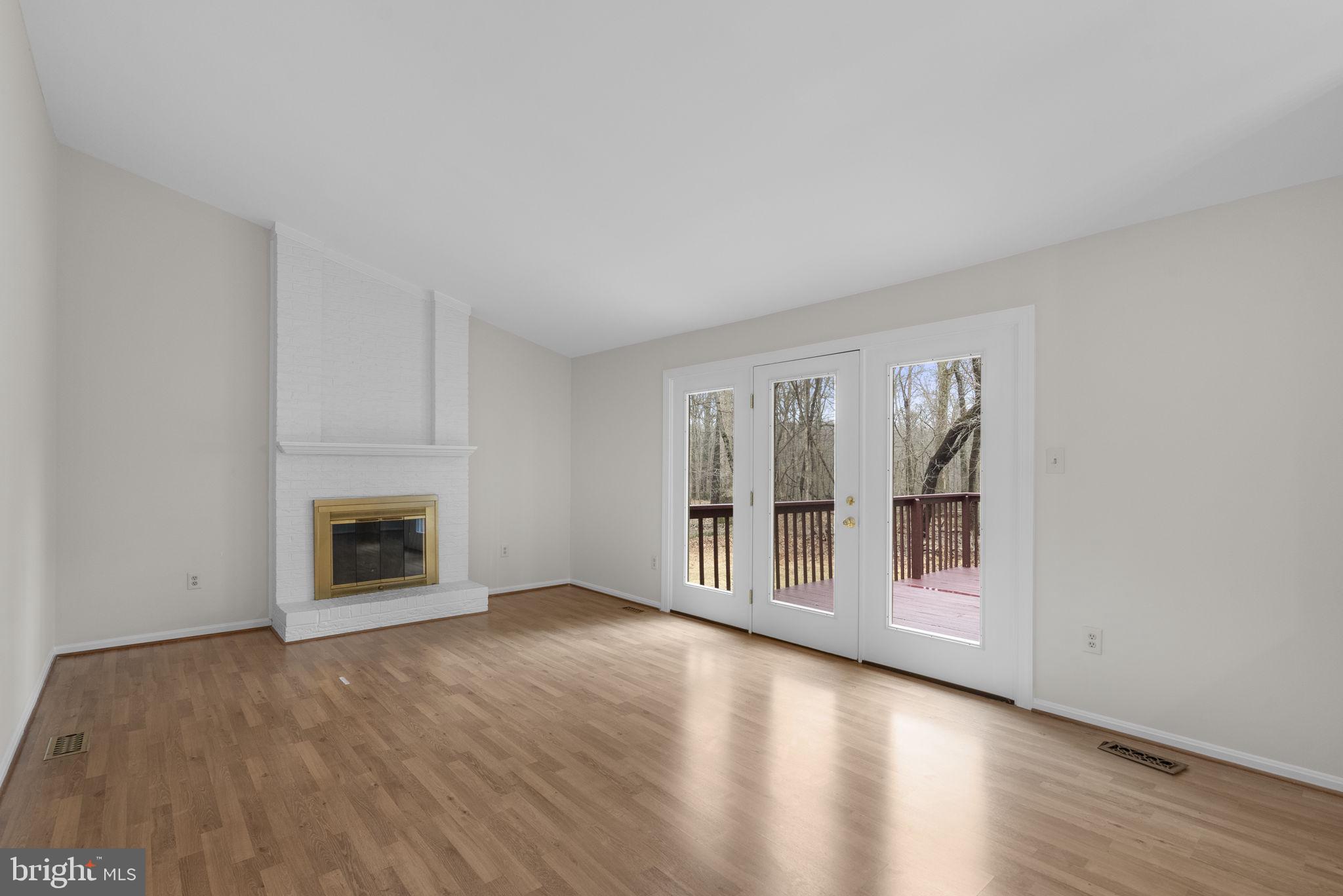 14724 Harvest Lane Silver Spring, MD 20905 - Photo 20 of 53 an empty room with wooden floor fireplace and windows