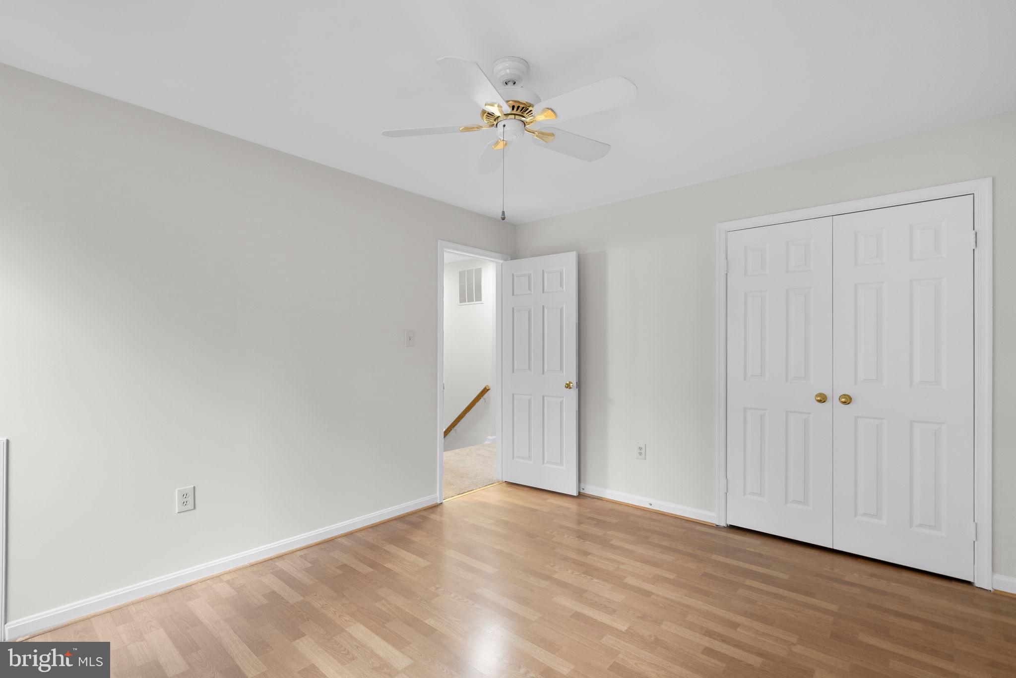 14724 Harvest Lane Silver Spring, MD 20905 - Photo 37 of 53 a view of an empty room with wooden floor and a ceiling fan