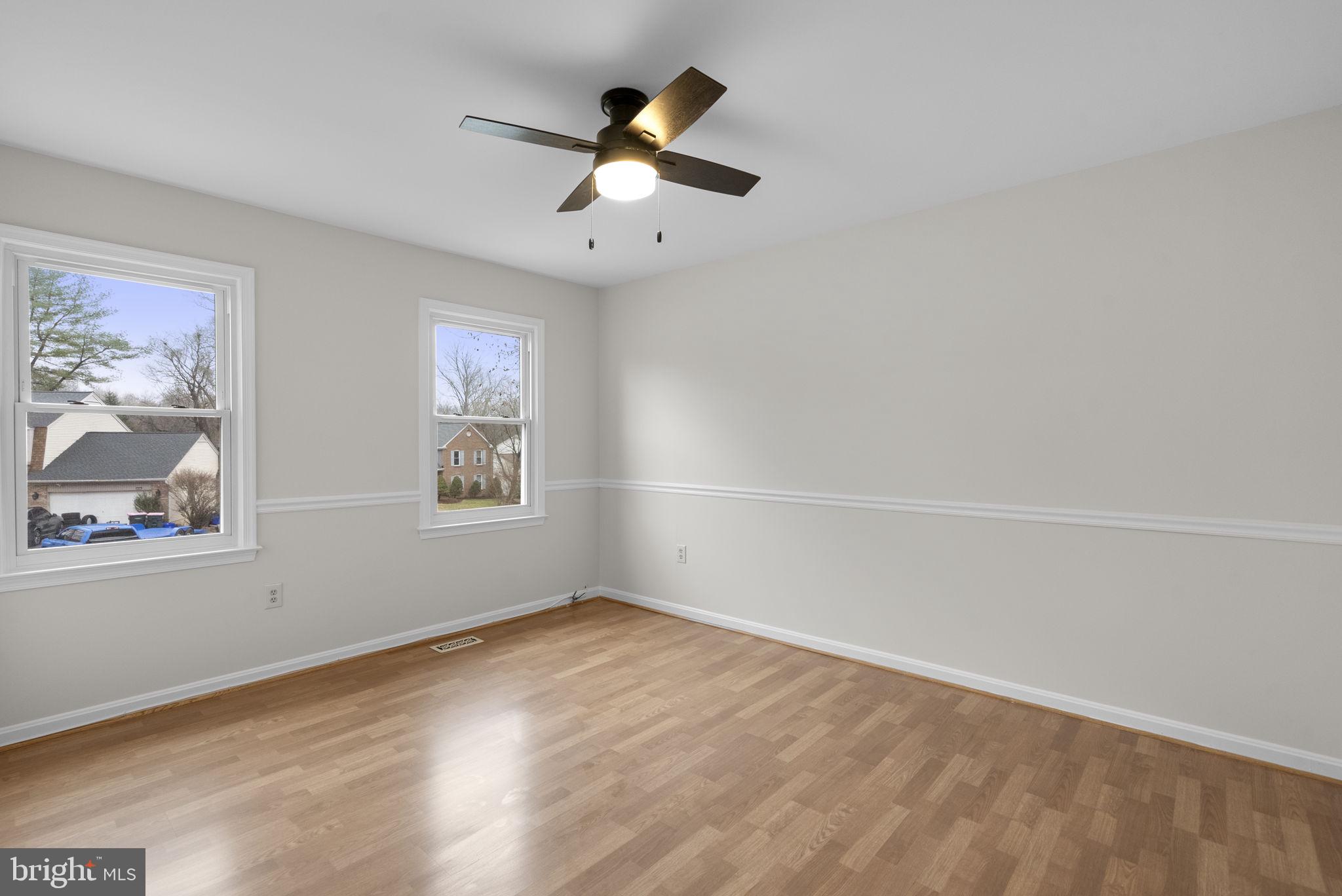 14724 Harvest Lane Silver Spring, MD 20905 - Photo 39 of 53 an empty room with wooden floor chandelier fan and windows
