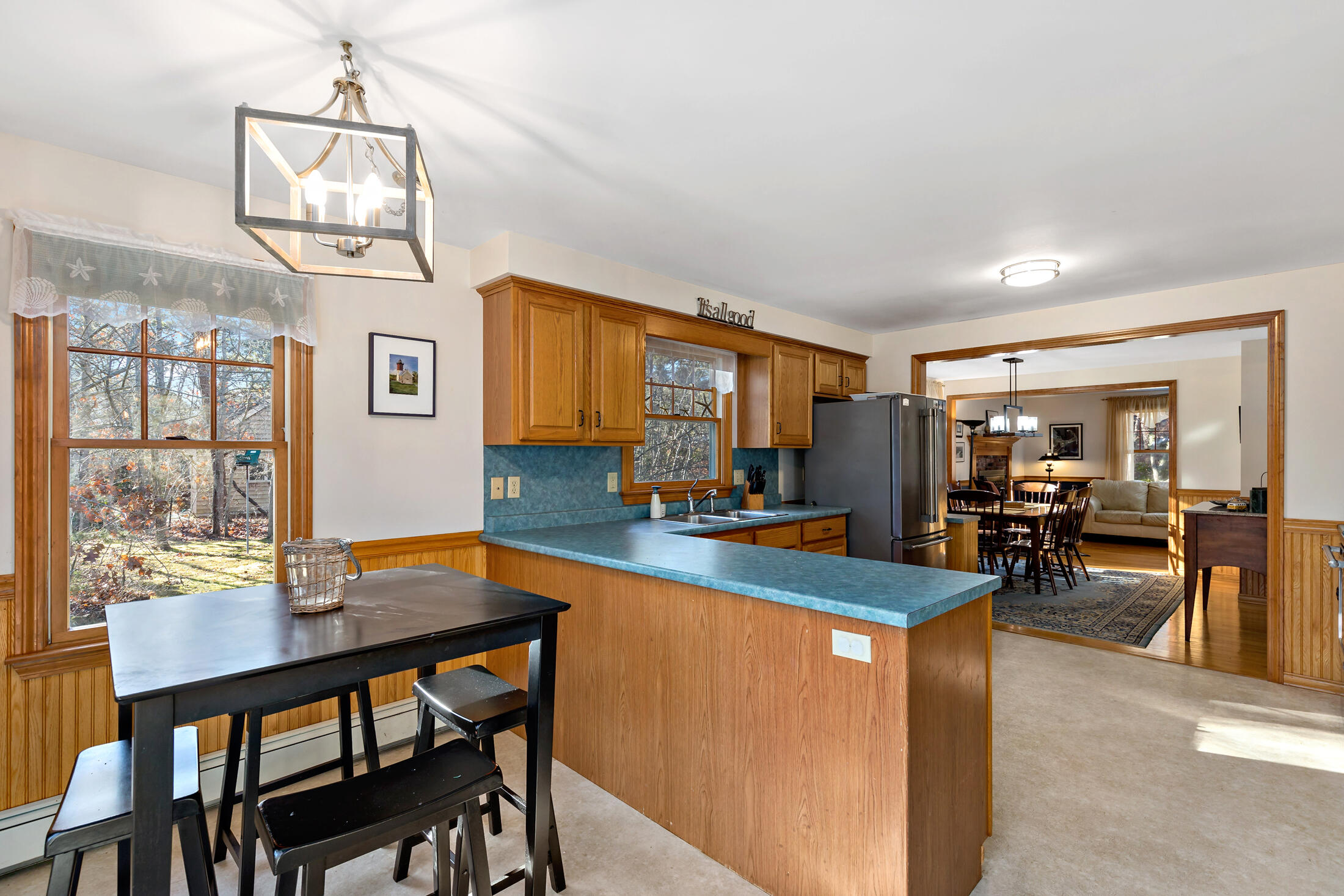 25 Forrest Avenue Eastham, MA 02642 - Photo 16 of 46 a view of a dining room and livingroom with furniture wooden floor a rug a painting and a chandelier