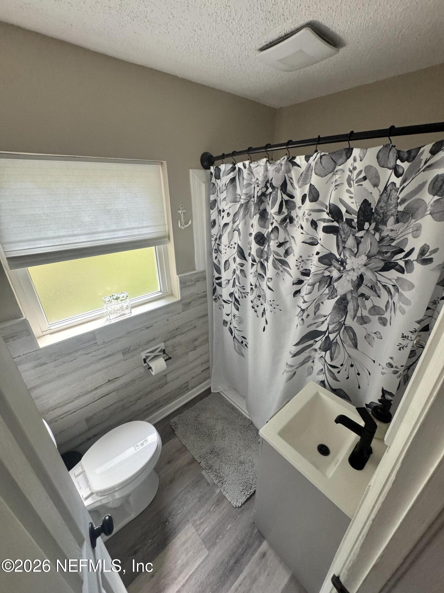 113 Stock Avenue Interlachen, FL 32148 - Photo 12 of 50 a bathroom with a toilet and a shower curtain