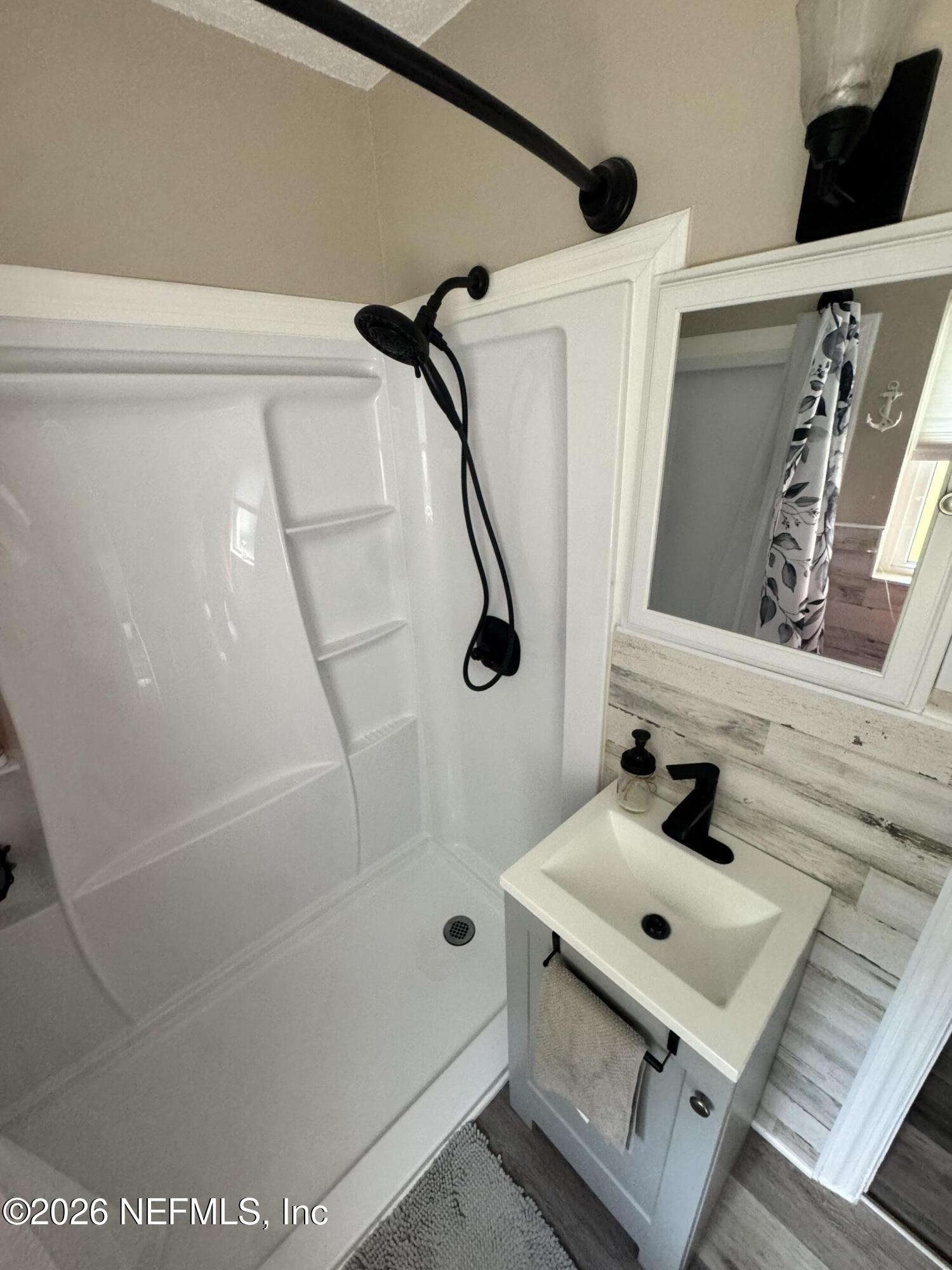 113 Stock Avenue Interlachen, FL 32148 - Photo 13 of 50 a bathroom with a sink mirror and shower