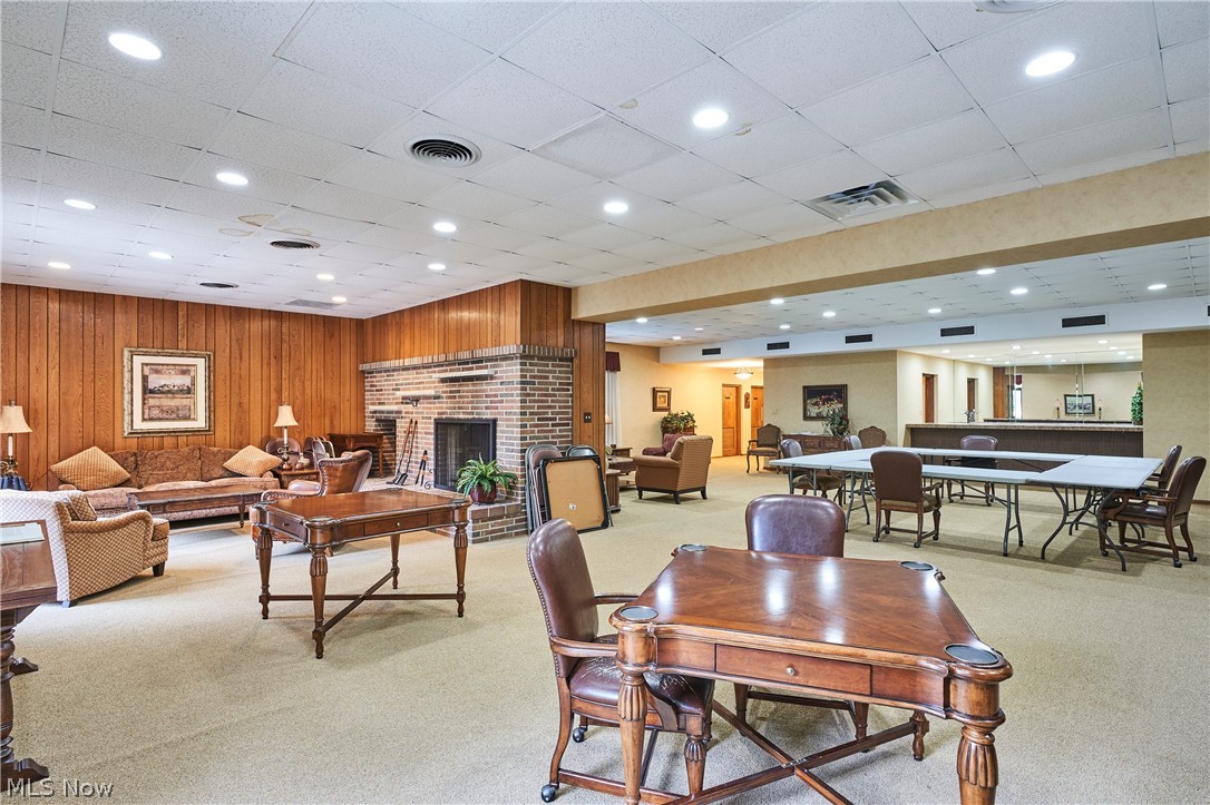 2385 Covington Road, Unit 304 Fairlawn, OH 44313 - Photo 21 of 21 Carpeted dining room with a brick fireplace, recessed lighting, wood walls, and a drop ceiling