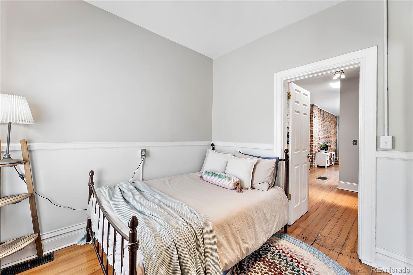 2546 West 23rd Avenue, Unit B Denver, CO 80211 - Photo 12 of 17 a bedroom with a bed and a lamp