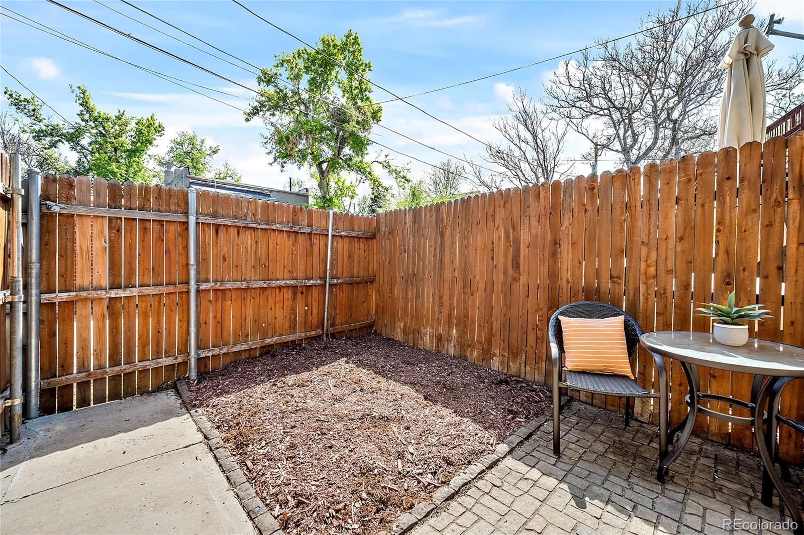 2546 West 23rd Avenue, Unit B Denver, CO 80211 - Photo 13 of 17 a backyard of a house with lawn chairs and wooden fence