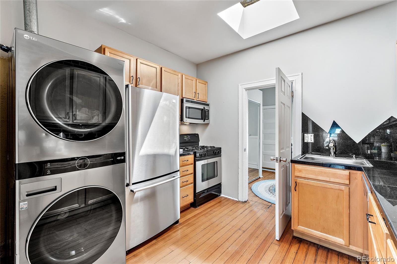 2546 West 23rd Avenue, Unit B Denver, CO 80211 - Photo 8 of 17 a kitchen with stainless steel appliances a stove a sink and a refrigerator