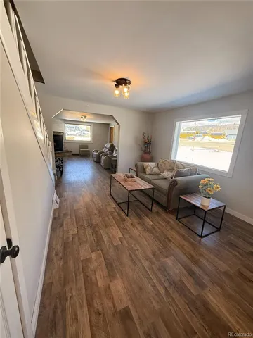 a living room with couches and a fireplace with wooden floor