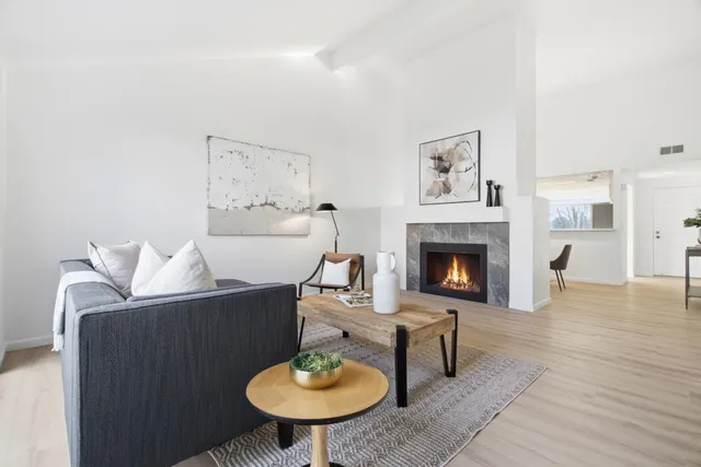 a living room with furniture a table and a fireplace