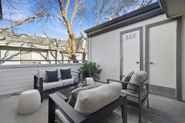 a view of a white house with a large windows and plants