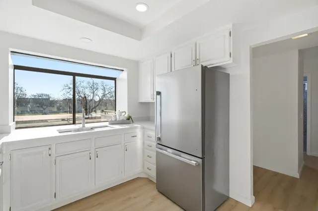 a kitchen with stainless steel appliances granite countertop a sink and a refrigerator