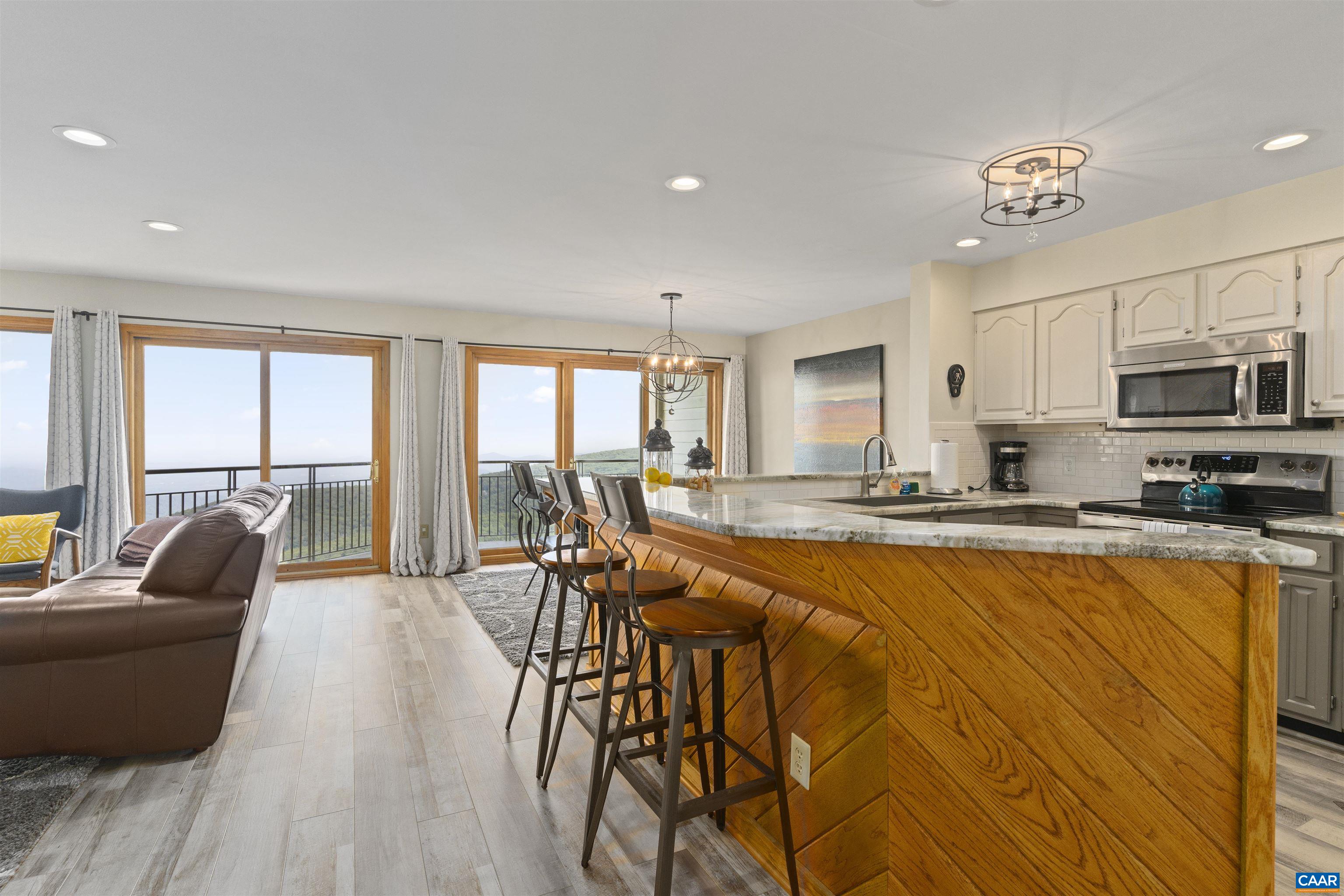 1581 Vistas Roseland, VA 22967 - Photo 30 of 53 a living room with stainless steel appliances granite countertop a couch a dining table and chairs with wooden floor