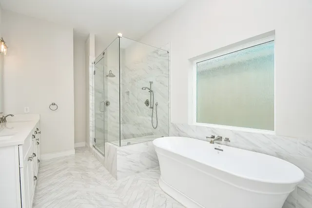 a bathroom with a tub sink shower and mirror