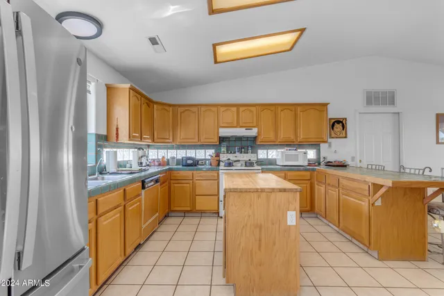 a kitchen with stainless steel appliances granite countertop a sink a stove and cabinets