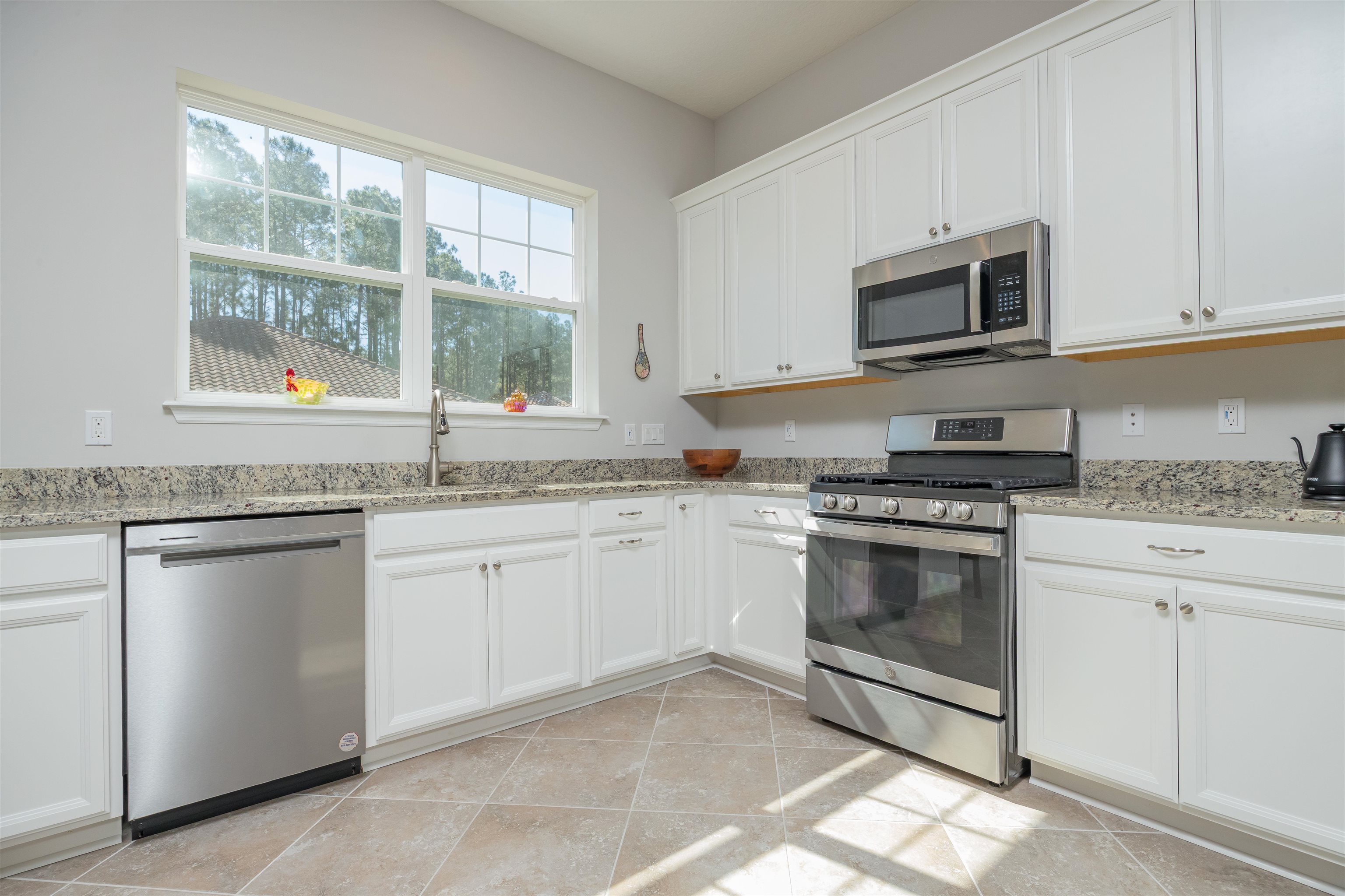 111 CanyonTrail St. Augustine, FL 32086 - Photo 21 of 55 a kitchen with granite countertop white cabinets stainless steel appliances and a sink