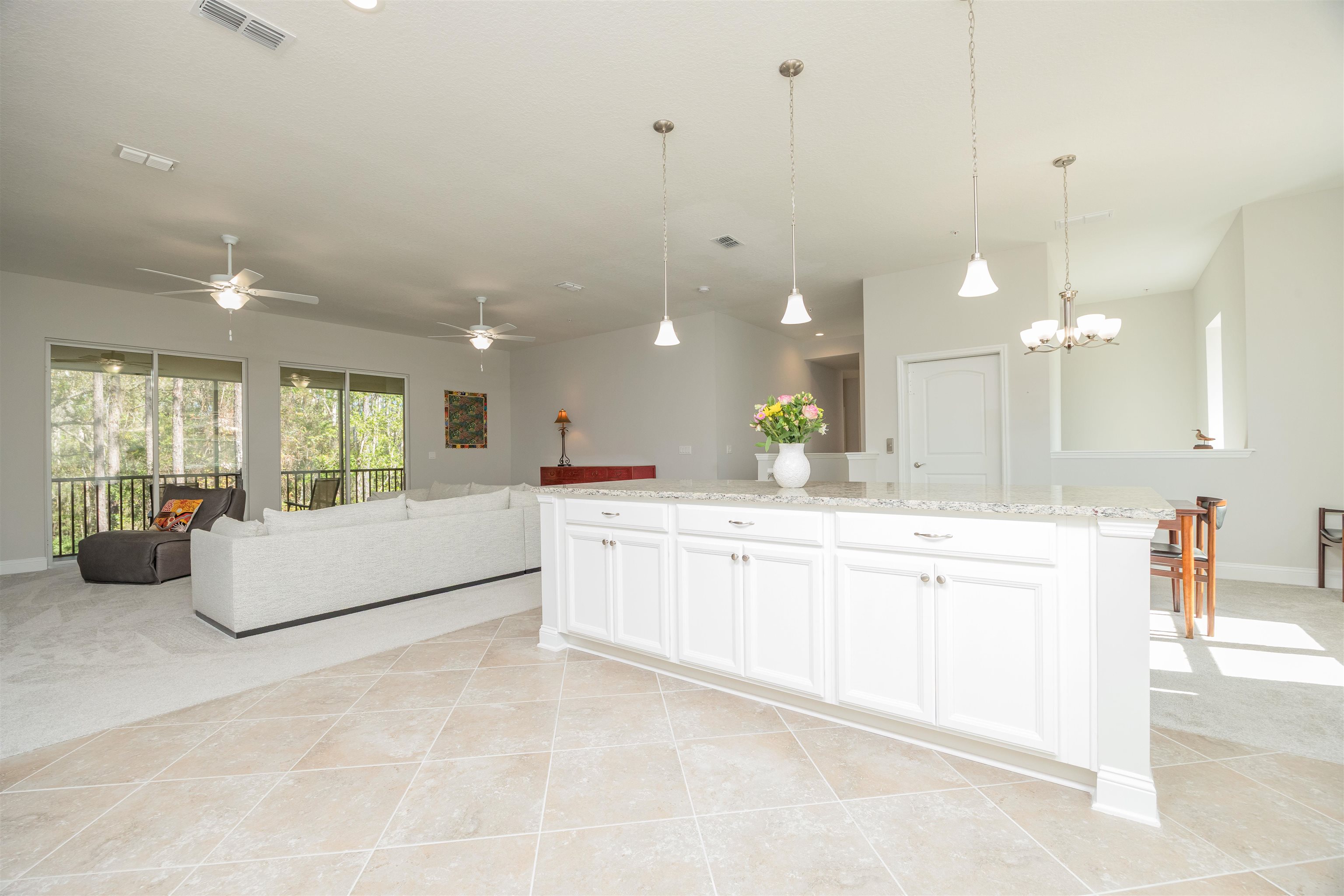 111 CanyonTrail St. Augustine, FL 32086 - Photo 23 of 55 a large white kitchen with a large island oven a sink dishwasher and a fireplace with wooden floor