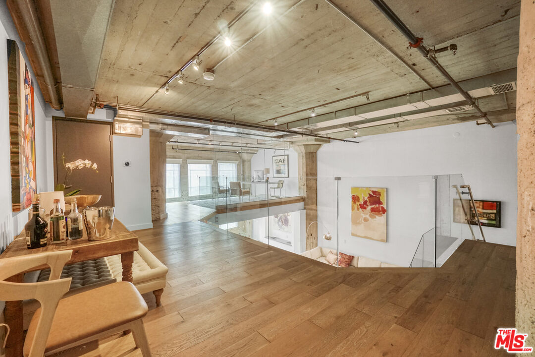 1855 Industrial Street, Unit 112 Los Angeles, CA 90021 - Photo 18 of 51 a room with lots of wooden furniture and large windows