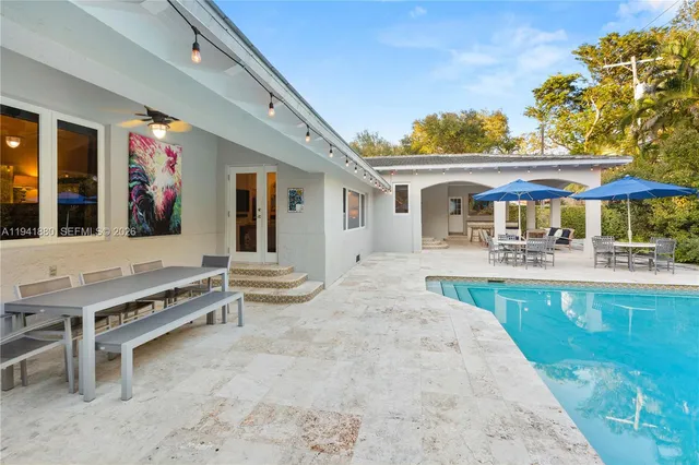 a view of a house with pool plants and palm trees
