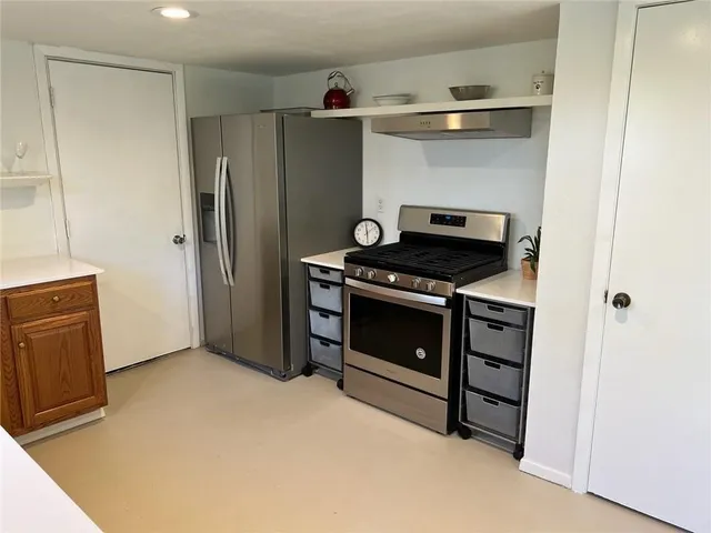 a kitchen with stainless steel appliances granite countertop a sink and a refrigerator