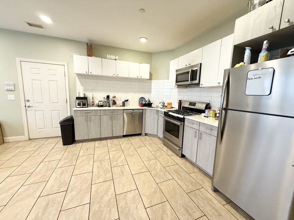 299 Dudley Street, Unit 1 Boston, MA 02119 - Photo 6 of 10 a kitchen with stainless steel appliances granite countertop a refrigerator sink and cabinets