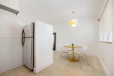 a dinning room with furniture and a chandelier fan