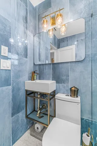 a bathroom with a sink a toilet and a mirror