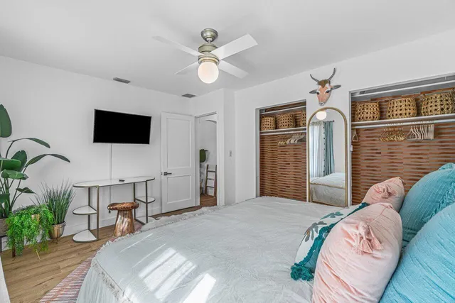 a bedroom with a bed a chandelier and a flat screen television