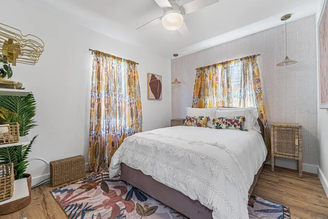 a bedroom with a bed wooden floor and potted plant