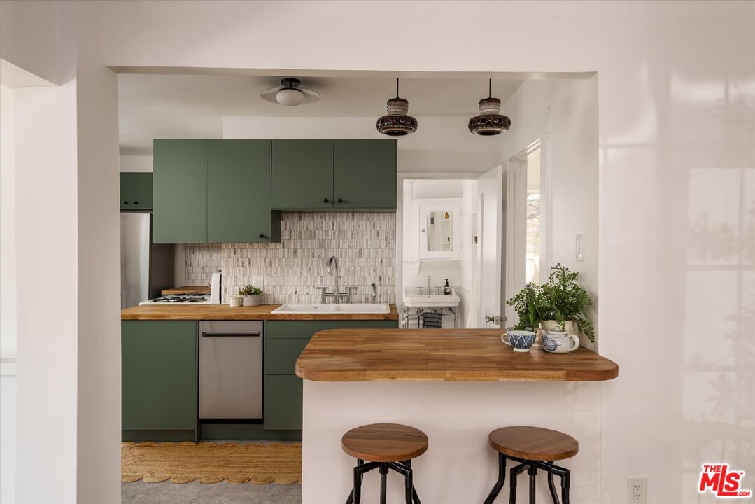 6036 Eucalyptus Lane Los Angeles, CA 90042 - Photo 10 of 34 a kitchen with stainless steel appliances a sink and cabinets